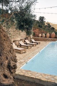 a swimming pool with chaise lounges next to at Eco Hotel Cueva del Gato in Benaoján