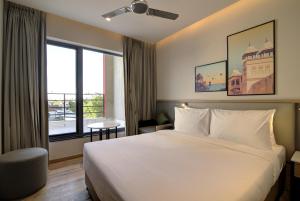 a hotel room with a bed and a large window at 7 Apple Hotel Pratap Nagar, Jaipur in Jaipur