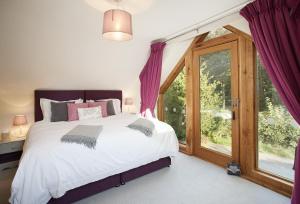 a bedroom with a bed and a large window at Orchard View 