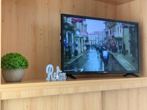 Elle comprend une télévision à écran plat installée sur un mur. dans l'établissement N-Apartman Central, à Mosonmagyaróvár