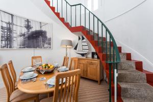 a dining room with a table and a staircase at Wolf Rock in Landewednack
