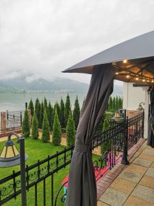 einen schwarzen Regenschirm auf einem Balkon mit Blick auf das Wasser in der Unterkunft Casa Dorin in Orşova