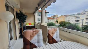 einen Balkon mit 2 Stühlen auf dem Balkon in der Unterkunft Mélodie Garage Gratuit in Cannes