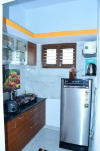 a kitchen with a stove and a refrigerator at Kailash Guest Home in Mysore