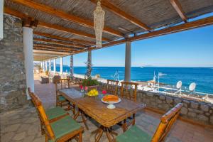 una mesa y sillas en un patio con vistas al océano en Estate4home - Villa San Montano, en Massa Lubrense