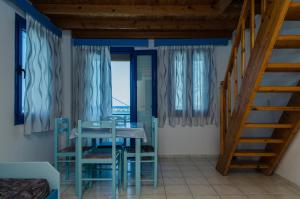 a room with a table and chairs and a staircase at Cleopatra Studios in Marathokampos