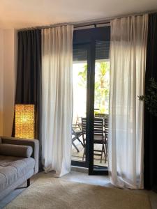 Una sala de estar con un sofá y puertas corredizas de vidrio. en Mar Jonica, 1 A2, en Denia 6 fotos más