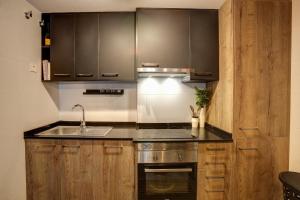 Una cocina con gabinetes de madera y un fregadero. en Mar Jonica, 1 A2, en Denia