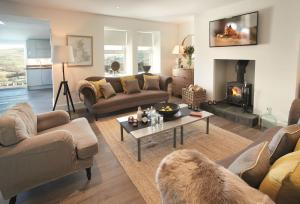 a living room with couches and a fireplace at Corriedow in Thornhill