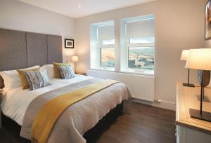 a bedroom with a large bed and two windows at Corriedow in Thornhill
