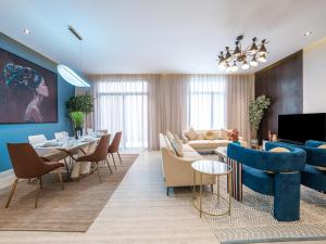 a living room with blue furniture and a dining room at Mabaat-Executive-Hittin 519 3BR-5-2 in Riyadh
