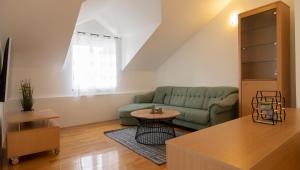 sala de estar con sofá verde y mesa en Mozart apartments en Baška Voda
