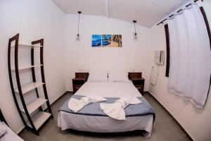 1 dormitorio con 1 cama con 2 toallas en Pedra do Porto Buzios, en Búzios