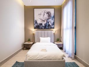 a bedroom with a bed and a painting on the wall at Mabaat-Executive-Hittin 519 3BR-5-2 in Riyadh