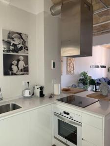 a white kitchen with a sink and a stove at Fantastico Tarragona Corsini Apartment-1, en el centro con parking in Tarragona
