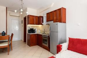 Una cocina con gabinetes de madera y un refrigerador blanco. en Villa Panorama, en Skala Potamias
