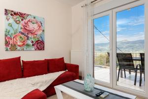 Una sala de estar con un sofá rojo y una gran ventana. en Villa Panorama, en Skala Potamias 81 fotos más