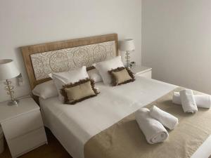 a bedroom with a large white bed with two pillows at Fantastico Tarragona Corsini Apartment-1, en el centro con parking in Tarragona