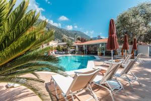 a group of chairs and umbrellas next to a pool at Bronze Hotel in Oludeniz