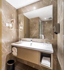 a bathroom with a sink and a mirror at Effotel By Sayaji Indore in Indore