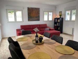 een woonkamer met een tafel en een rode bank bij Villa con piscina, soleada, tranquila y céntrica in Calpe