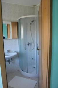 y baño con ducha y lavamanos. en Apartments Fičur with Swimming Pool & Grill, Portorož, en Portorož