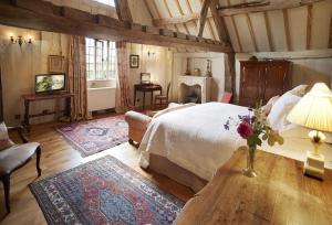 a bedroom with a bed and a table with flowers on it at Elinor Fettiplace in Pauntley