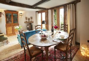 a dining room with a wooden table and chairs at Elinor Fettiplace in Pauntley