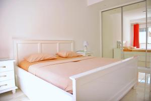 a white bedroom with a bed and a mirror at Duarte Apartments - Laginha in Mindelo