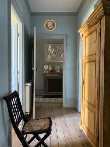 una habitación con una silla y un reloj en la pared en Manoir de Ghaisne en Freigné