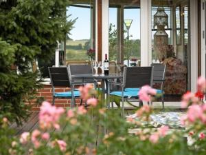 eine Veranda mit Stühlen und einem Tisch mit Weinflaschen in der Unterkunft Holiday Home Eleana - 300m to the inlet in Sealand by Interhome in Roskilde