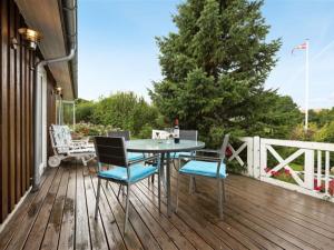 einen Tisch und Stühle auf einer Holzterrasse in der Unterkunft Holiday Home Eleana - 300m to the inlet in Sealand by Interhome in Roskilde