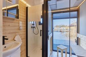 a bathroom with a sink and a toilet and a window at Hausboot mit Sauna Świnoujście, Houseboat Marina Karsib&oacute;r in Świnoujście
