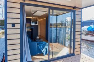 a room with sliding glass doors on a boat at Hausboot mit Sauna Świnoujście, Houseboat Marina Karsib&oacute;r in Świnoujście