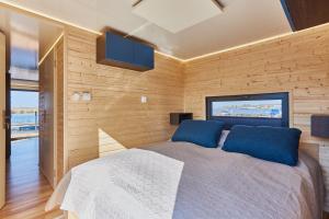a bedroom with a large bed with blue pillows at Hausboot mit Sauna Świnoujście, Houseboat Marina Karsib&oacute;r in Świnoujście