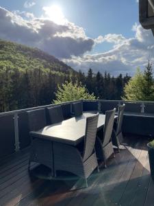 una terraza de madera con mesa y sillas. en Hochheide Lodge en Winterberg