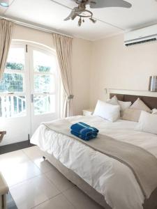 a bedroom with a bed with a blue bag on it at Caribbean Estates Villa 7B in Port Edward