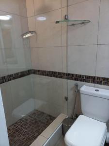 a white bathroom with a shower and a toilet at Caribbean Estates Villa 7B in Port Edward