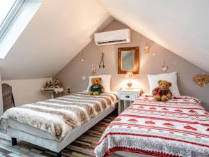 メルヴィル・フランスヴィル・プラージュにあるHoliday Home La Villa bleue by Interhomeのテディベア付きの屋根裏のベッドルームのベッド2台