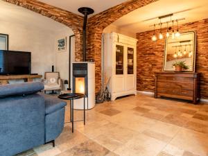 uma sala de estar com um sofá azul e uma parede de tijolos em Holiday Home La Villa bleue by Interhome em Merville-Franceville-Plage
