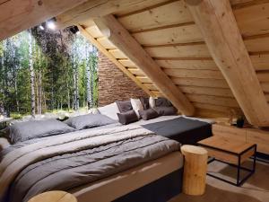 a large bed in a room with wooden ceilings at Chalet KuŘíp by Interhome in Benešov nad Černou