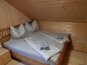 a bed in a cabin with two pairs of slippers at Holiday Home Ferienhaus Reiter by Interhome in Rohrbach