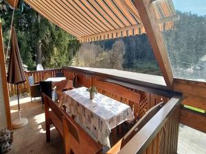 una terraza de madera con una mesa y una ventana grande en Holiday Home Ferienhaus Reiter by Interhome, en Rohrbach