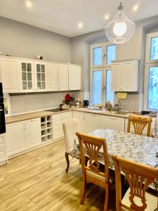 a kitchen with white cabinets and a table and chairs at 1 Bedroom Lux Apartment Center Vincent in Wrocław