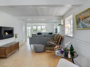 ein Wohnzimmer mit einem Sofa und einem Tisch in der Unterkunft Holiday Home Gyril - all inclusive - 100m from the sea by Interhome in Sønderby