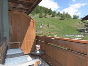 a porch with a bench and a view of a hill at Apartment Wiedersehen by Interhome in Saas-Grund