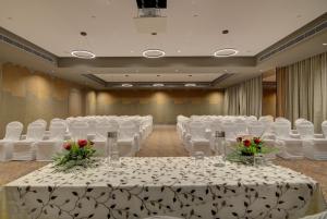 un salón de banquetes con mesas blancas, sillas y flores en 7 Apple Hotel Pratap Nagar, Jaipur en Jaipur