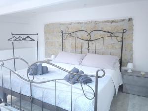 a bedroom with a wrought iron bed with white sheets at La casetta nel vicolo in Palermo