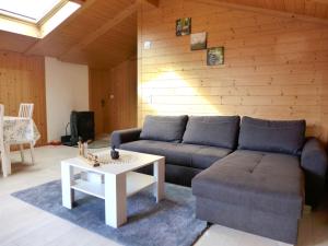 a living room with a couch and a table at Apartment Chalet Vamika by Interhome in Niederried