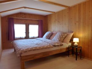 a bedroom with a large bed with a window at Apartment Chalet Vamika by Interhome in Niederried